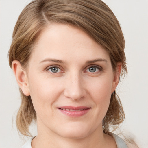 Joyful white young-adult female with medium  brown hair and grey eyes