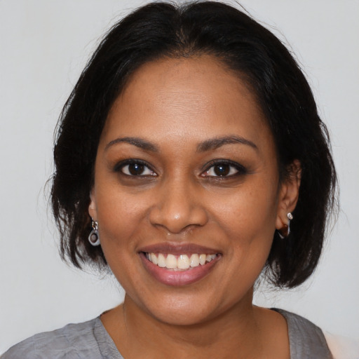 Joyful black young-adult female with medium  brown hair and brown eyes