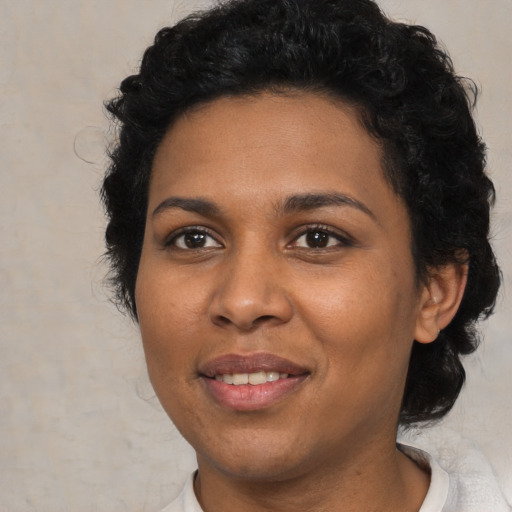 Joyful black young-adult female with short  black hair and brown eyes