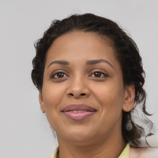 Joyful latino adult female with medium  brown hair and brown eyes