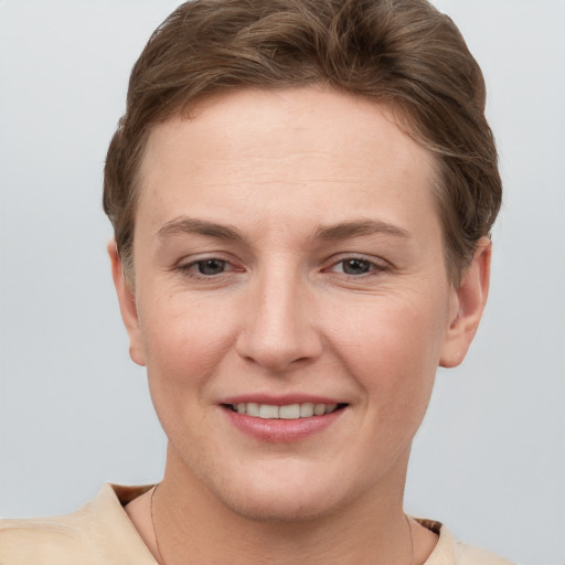 Joyful white young-adult female with short  brown hair and grey eyes