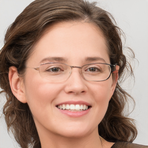 Joyful white adult female with medium  brown hair and green eyes