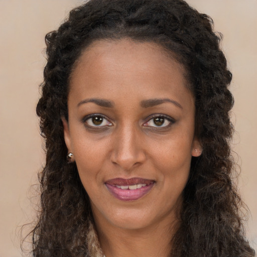 Joyful black young-adult female with long  brown hair and brown eyes