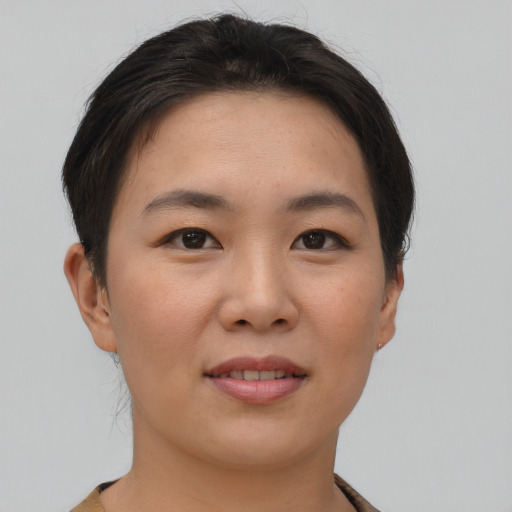 Joyful asian young-adult female with short  brown hair and brown eyes