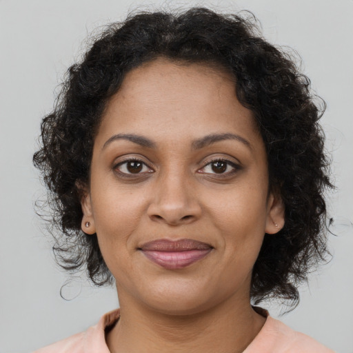 Joyful black young-adult female with medium  brown hair and brown eyes