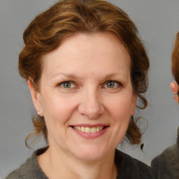 Joyful white adult female with medium  brown hair and blue eyes