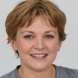 Joyful white young-adult female with medium  brown hair and grey eyes