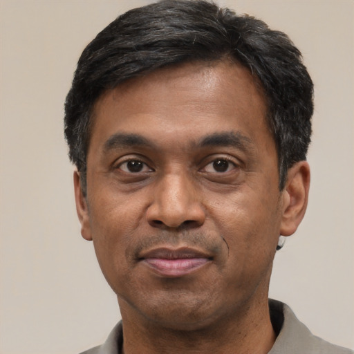 Joyful latino adult male with short  black hair and brown eyes