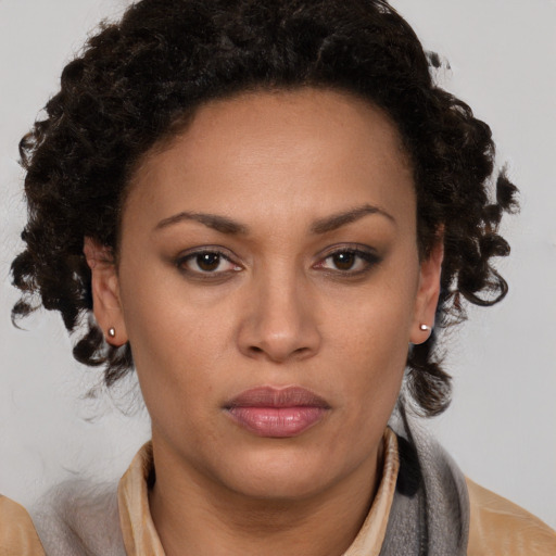 Joyful black adult female with medium  brown hair and brown eyes