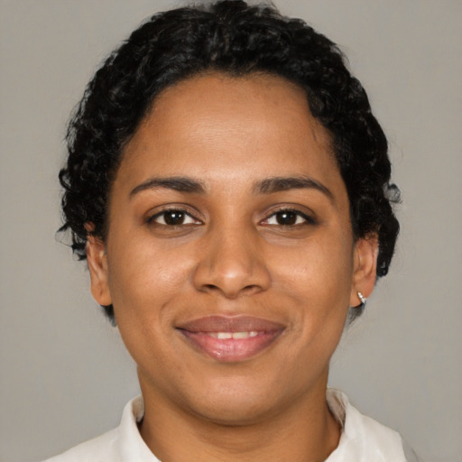 Joyful black young-adult female with short  brown hair and brown eyes