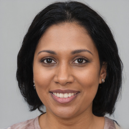 Joyful black young-adult female with medium  brown hair and brown eyes