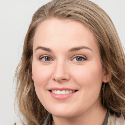 Joyful white young-adult female with long  brown hair and blue eyes