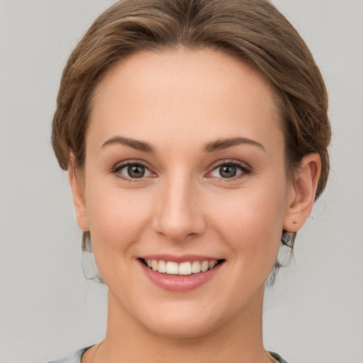 Joyful white young-adult female with medium  brown hair and green eyes