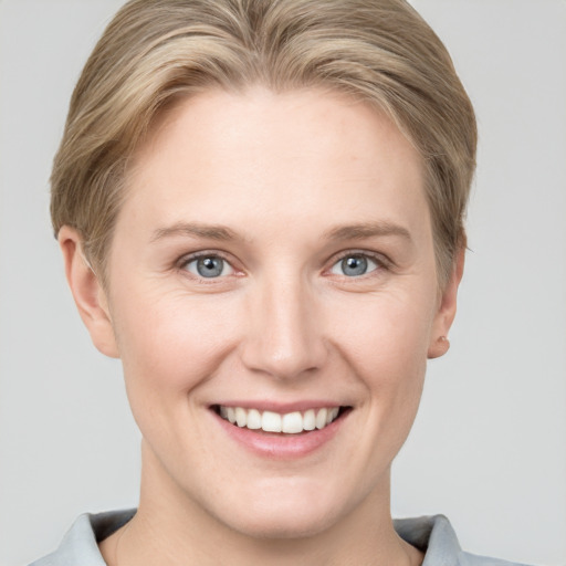 Joyful white young-adult female with short  brown hair and grey eyes