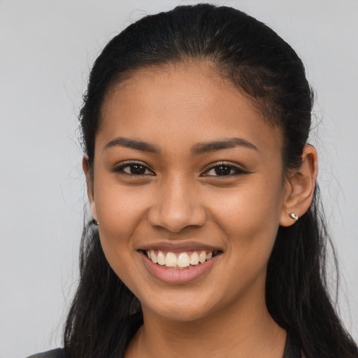 Joyful latino young-adult female with long  brown hair and brown eyes