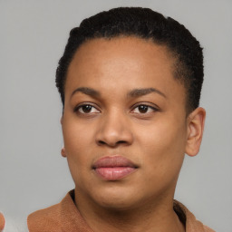 Joyful black young-adult female with short  black hair and brown eyes