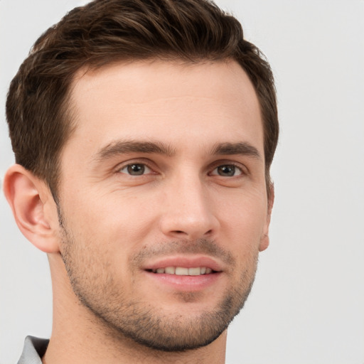 Joyful white young-adult male with short  brown hair and grey eyes