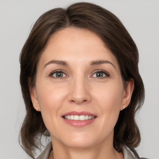 Joyful white young-adult female with medium  brown hair and grey eyes