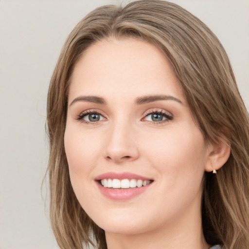 Joyful white young-adult female with long  brown hair and green eyes