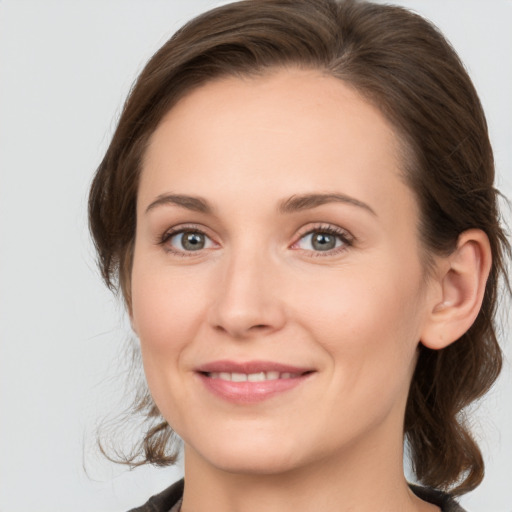 Joyful white young-adult female with medium  brown hair and grey eyes