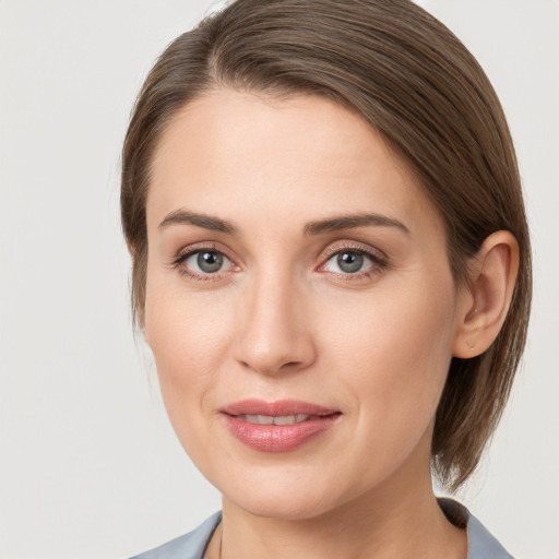 Joyful white young-adult female with medium  brown hair and grey eyes