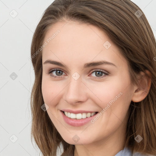 Joyful white young-adult female with long  brown hair and grey eyes