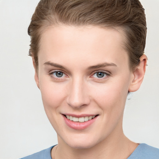 Joyful white young-adult female with short  brown hair and grey eyes