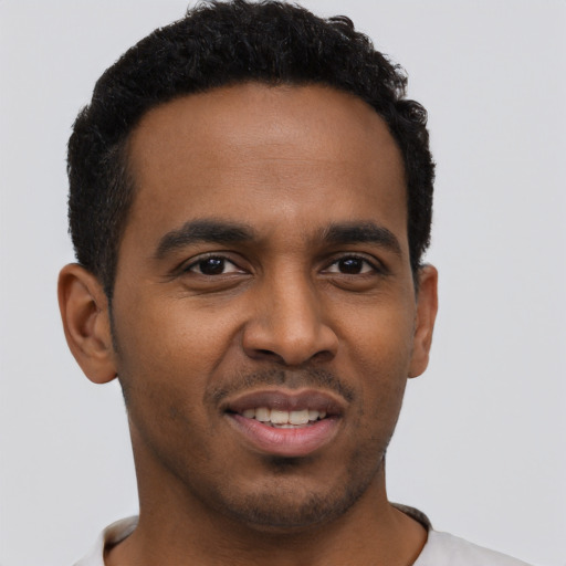 Joyful black young-adult male with short  black hair and brown eyes