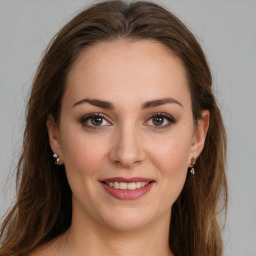 Joyful white young-adult female with long  brown hair and green eyes