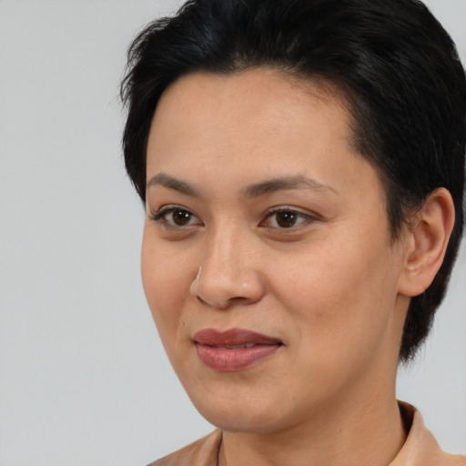 Joyful latino young-adult female with short  black hair and brown eyes