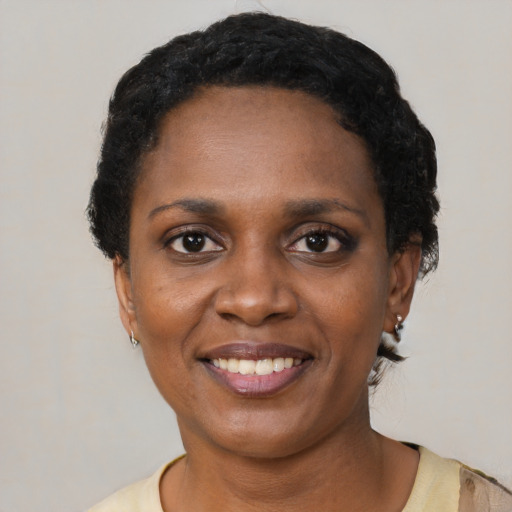 Joyful black young-adult female with short  black hair and brown eyes