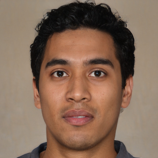 Joyful latino young-adult male with short  black hair and brown eyes