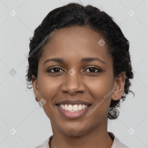 Joyful black young-adult female with short  black hair and brown eyes