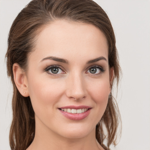 Joyful white young-adult female with medium  brown hair and grey eyes