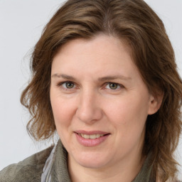 Joyful white adult female with medium  brown hair and blue eyes