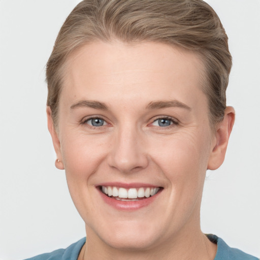 Joyful white young-adult female with short  brown hair and grey eyes