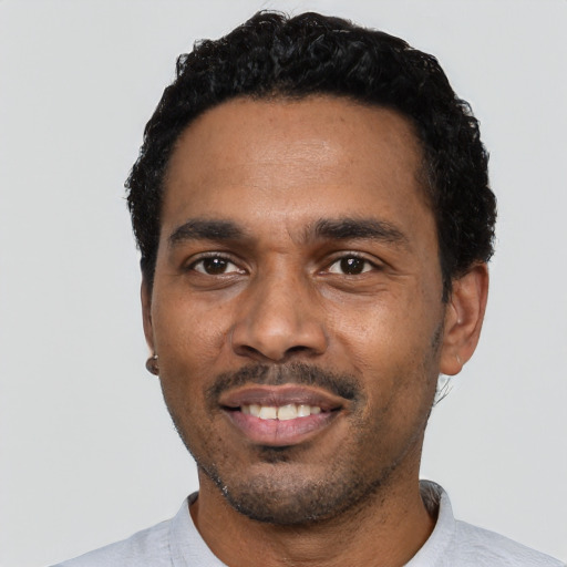Joyful black young-adult male with short  black hair and brown eyes