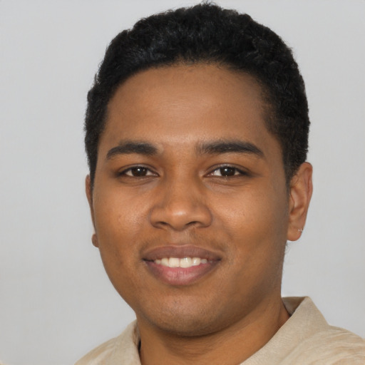 Joyful black young-adult male with short  black hair and brown eyes