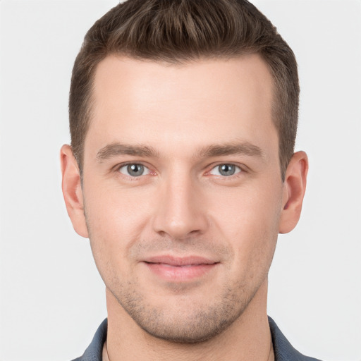 Joyful white young-adult male with short  brown hair and grey eyes