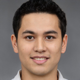 Joyful latino young-adult male with short  brown hair and brown eyes