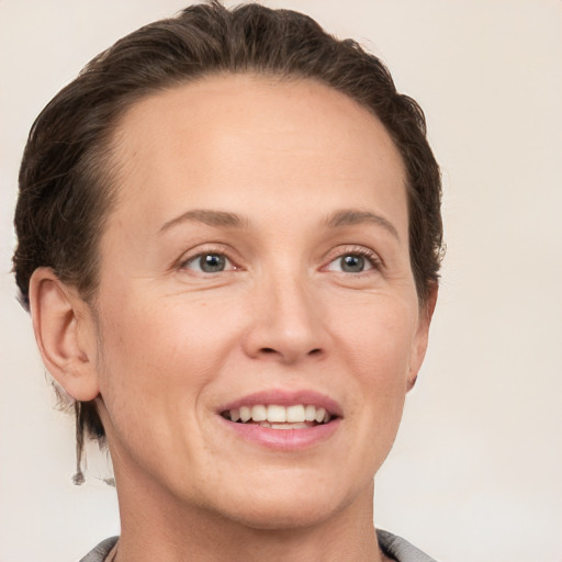 Joyful white young-adult female with short  brown hair and grey eyes