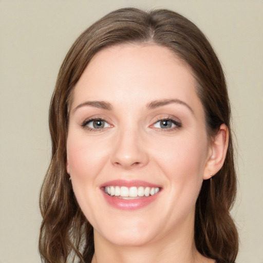 Joyful white young-adult female with medium  brown hair and green eyes