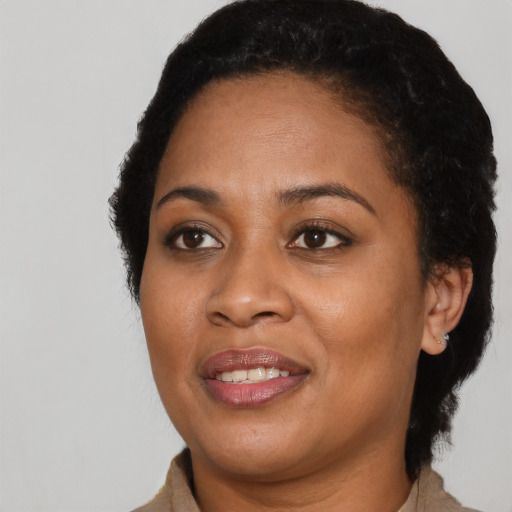 Joyful black young-adult female with short  black hair and brown eyes