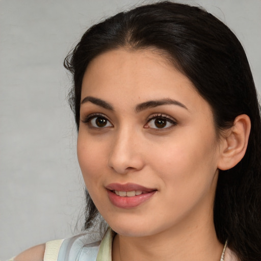 Joyful white young-adult female with medium  black hair and brown eyes