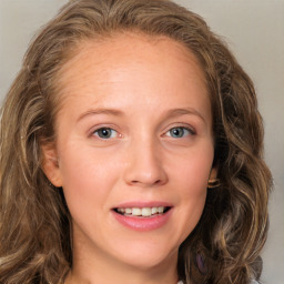 Joyful white young-adult female with long  brown hair and blue eyes