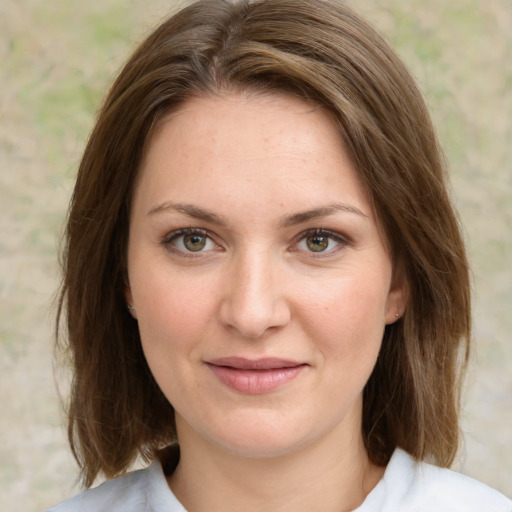 Joyful white young-adult female with medium  brown hair and green eyes