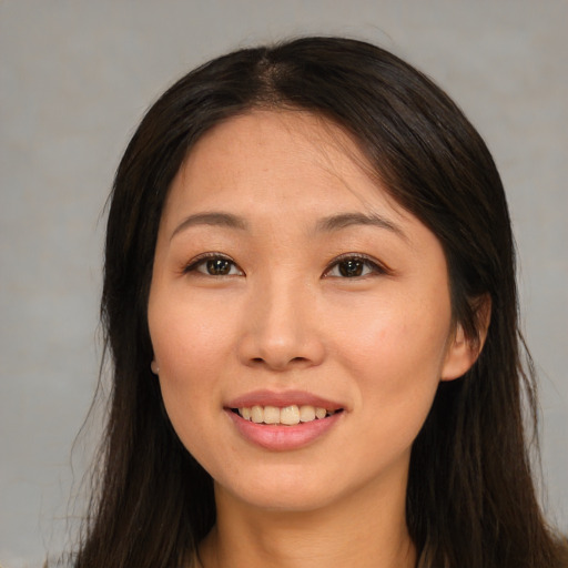 Joyful asian young-adult female with long  brown hair and brown eyes