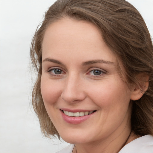 Joyful white adult female with medium  brown hair and grey eyes