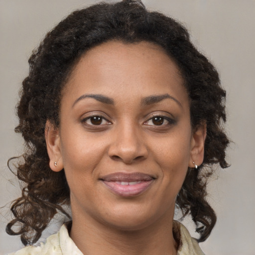 Joyful black young-adult female with medium  brown hair and brown eyes