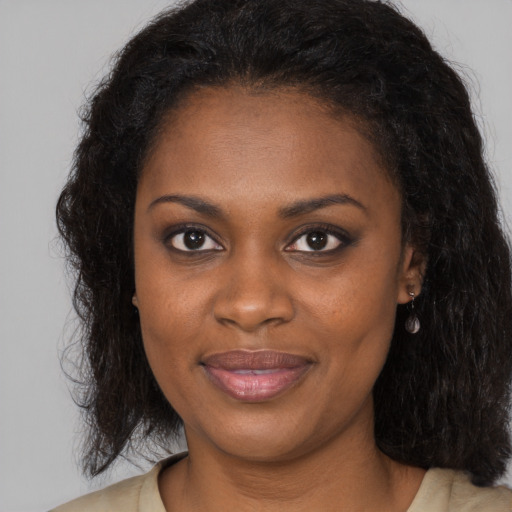 Joyful black young-adult female with long  brown hair and brown eyes